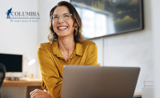 Woman with laptop smiling.