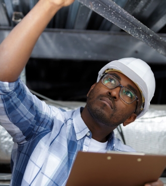 Man inspects roof from the inside.